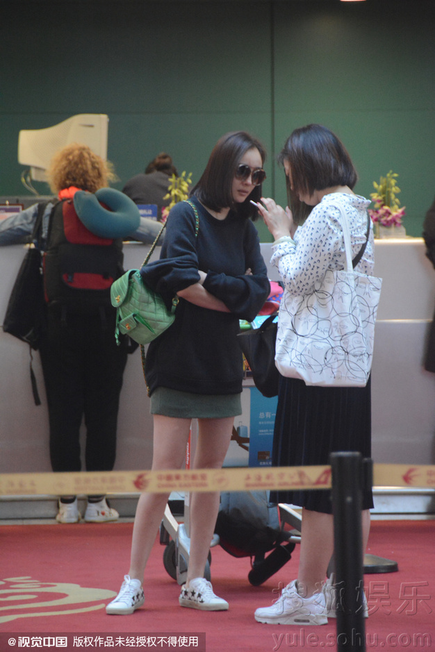 杨幂穿短裙现身机场秀美腿 与助理热聊任拍80