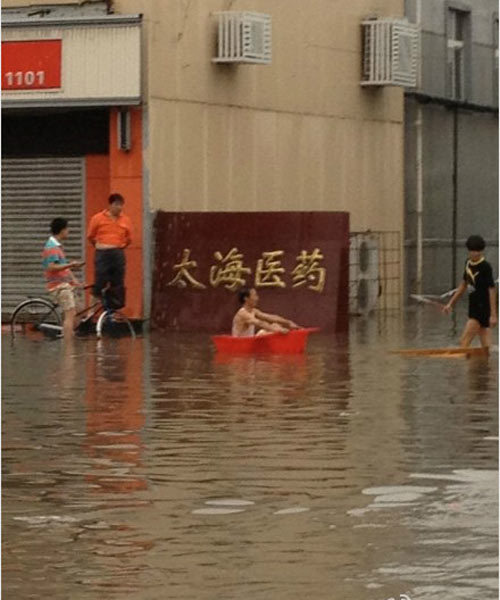 天津遭遇暴雨袭击一片汪洋 市民不忘“雨中取乐”(组图)