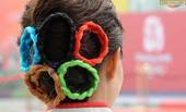 7月27日北京奥运村开村，这是拍摄的一名礼仪小姐的五环头饰。别致的发式映衬着美丽的微笑，北京以热烈的...