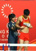 刘翔在11日预赛前更换战衣时，因为背心太紧，穿到一半实在拉不下来了，最终只得求助身后的志愿者帮忙，没...